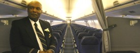 Flight attendant Robert Johnson stands in between first class and coach on an American Airlines 737-800 plane in 2009. (Stacey Wescott/Chicago Tribune)