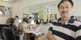 Phu Bui stands in his Chicago nail salon featured ad on Groupon.com. He thought 1,000 customers would bite on the deal but instead, he had 5,146 responses. (AP/M. Spencer Green)