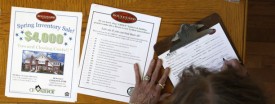 A woman fills out a form to receive more information after touring a new home for sale in St. Louis, Aug. 25, 2010. Mortgage rates continue to drop. (AP Photo/Jeff Roberson)